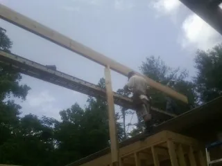 Carpenter setting a ridge beam over a new addition frame in West Wareham
