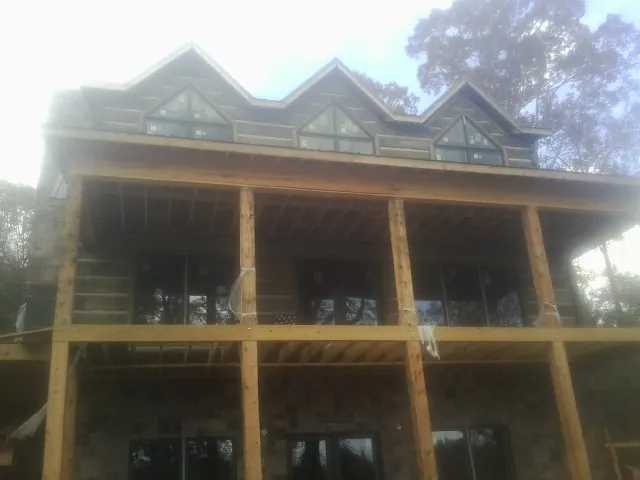 Dormers and porch framing on a large log home under construction — Roof Coating work by our crew in West Wareham