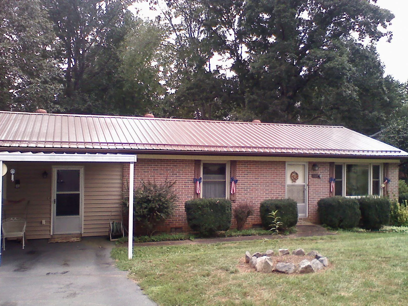 Bronze metal roof and carport on a brick ranch home — Roof Repair work by our crew in West Wareham